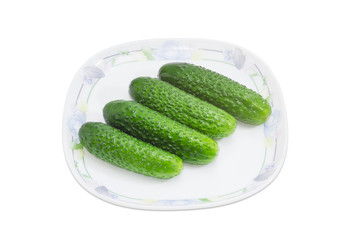 Several cucumbers on a dish on a light background