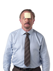 mature businessman looking at a sticky note on his forehead.