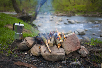 The fire in the clearing near the river.