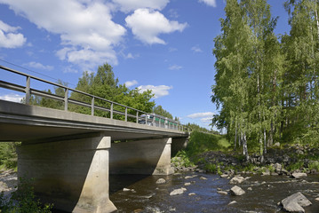 Fototapeta premium Bridge across northern river with rapids