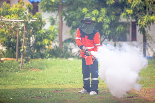 Worker fogging residential area with insecticides to kill aedes