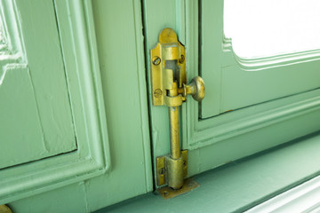The Vintage wooden window with gold iron locked bolt