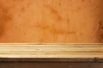 Empty wooden deck table over old yellow orange wall background