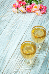 Two glasses of white wine and flowers