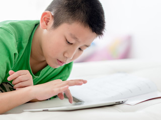 Boy using tablet at home, selective focus at tablet.