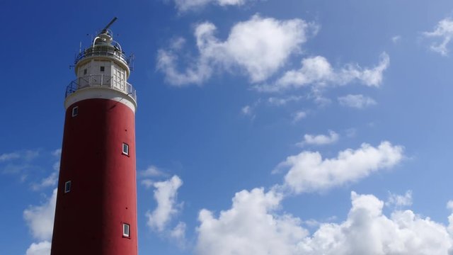 Red Lighthouse placed in the dunes near to the beach. Lighthouses are nautical navigation marks for the shipping industry.