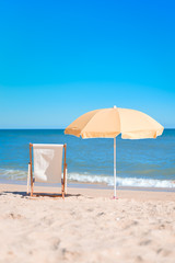 Back View Of Deckchair, Sun Lounger Under Umbrella On Sand Beach. 