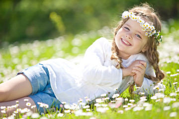 Happy kid in a camomile field 