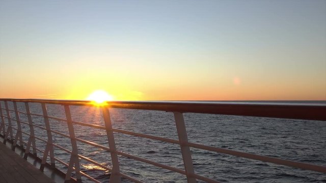 Sun shines through cruise ship deck and railing at sunset