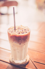 Ice coffee on wood table background. Shallow dept of field. Drink background concept.