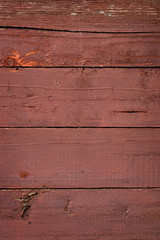Texture of old wooden fence painted in red paint