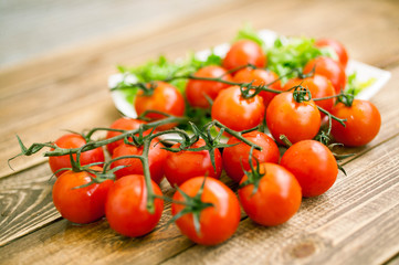 Red fresh tasty cherry tomatoes on a wooden table