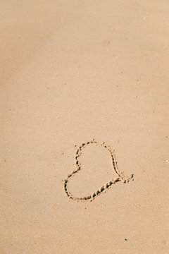 Love heart sign on the wet beach sand sea wave background