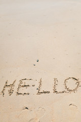 Hello sign word drawing on the outside sand beach background