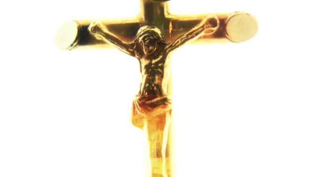 Zoom and rotate on a statue of Jesus Christ on the cross, isolated on white background, with fire flames as an overlay.