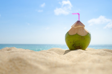 Coconut drink on sand beach.
