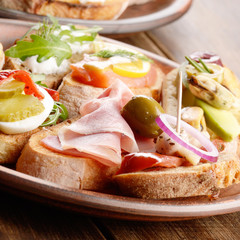 Open sandwiches with salmon, eggs, mussels, jamon and herring