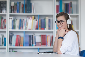 female student study in library, using tablet and searching for