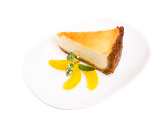 Classic cheesecake with mint and sliced peach.