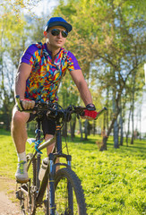 A man on a Bicycle rides through the Park