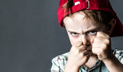 threatening boy with freckles and red hat back looking violent - obrazy, fototapety, plakaty