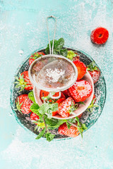 Strawberries bowls with powdered sugar, top view, close up