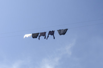 Clothes hanging on a clothesline in front of blue sky