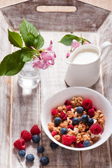 Healthy breakfast Fresh granola, muesli in bowl with milk and berries 