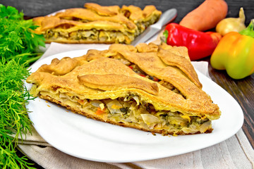 Pie with cabbage and sorrel in plate on dark board
