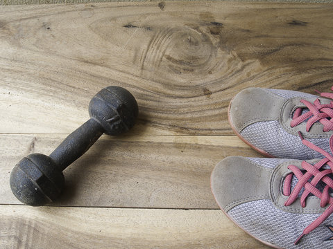 metal dumbbell and shoe on a old wooden background