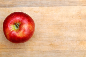 Red apple on wooden table background