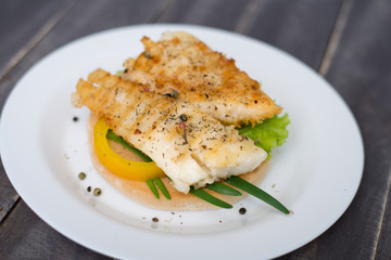 Fishburger with pepper and green onion on the stone blackboard