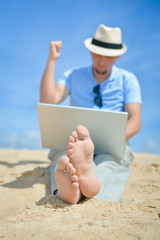 Happy busy business man working using computer, beach blue sky background