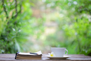 Notebook with pencil and cup on wooden table
