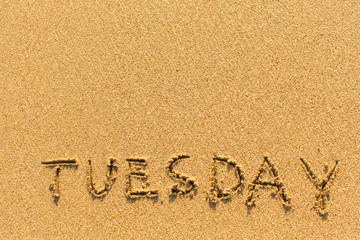 Tuesday - inscription by hand on a light-golden beach sand.
