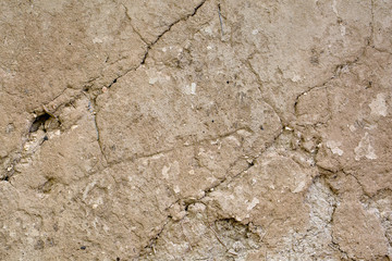 Cracked beige clay wall . Background. Texture