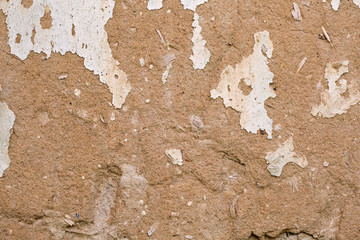 Cracked white paint on a wall of clay. Grunge wall of the old house, textured background