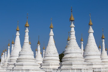 Fototapeta premium White Pagoda at blue sky background in Mandalay, Myanmar, Burma