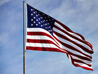 Flag USA waving in wind on blue sky and clouds