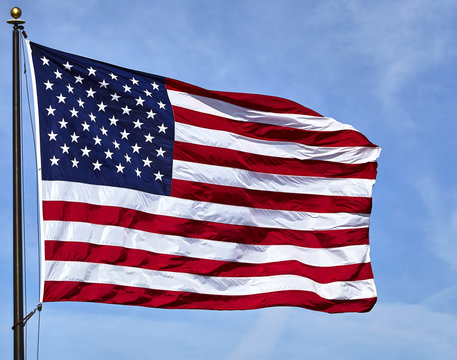 Flag USA waving in wind with blue sky and clouds