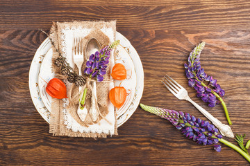 Tableware with violet Lupinus, Physalis and silverware