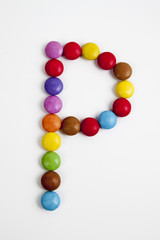 La lettera P formata da coloratissimi confetti di cioccolato.