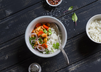Beans in tomato sauce and rice - a delicious vegetarian lunch. On a dark wooden background