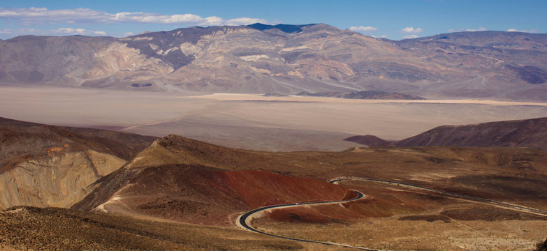 Long winding heart-shaped highway dropping into a sandy desert valley in Death Valley