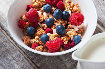 Healthy breakfast Fresh granola, muesli in bowl with milk and berries