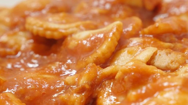 Dough ravioli in the tomato sauce with cheese food background 4K 2160p 30fps UltraHD slow tilt video - Filled with meat ravioli pasta dough served for lunch 4K 3840X2160 UHD footage 