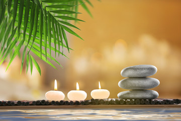 Composition with spa stones and candles on blurred background
