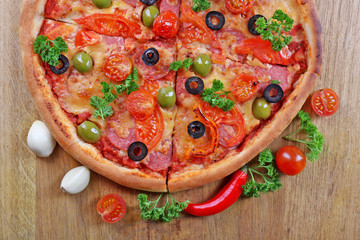 Tasty pizza with sausage and vegetables on wooden table background