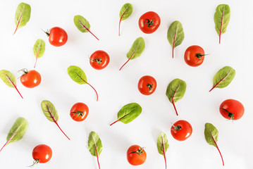 Beet leaves and tomatoes on white background. Top view, Flat lay.