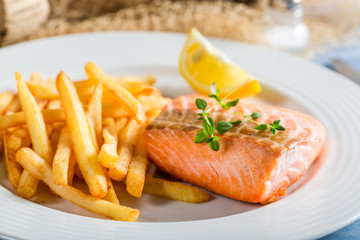 Closeup of delicious salmon with chips with lemon